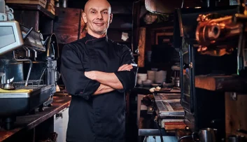 confident-chef-wearing-uniform-posing-with-his-arms-crossed-looking-camera-restaurant-kitchen